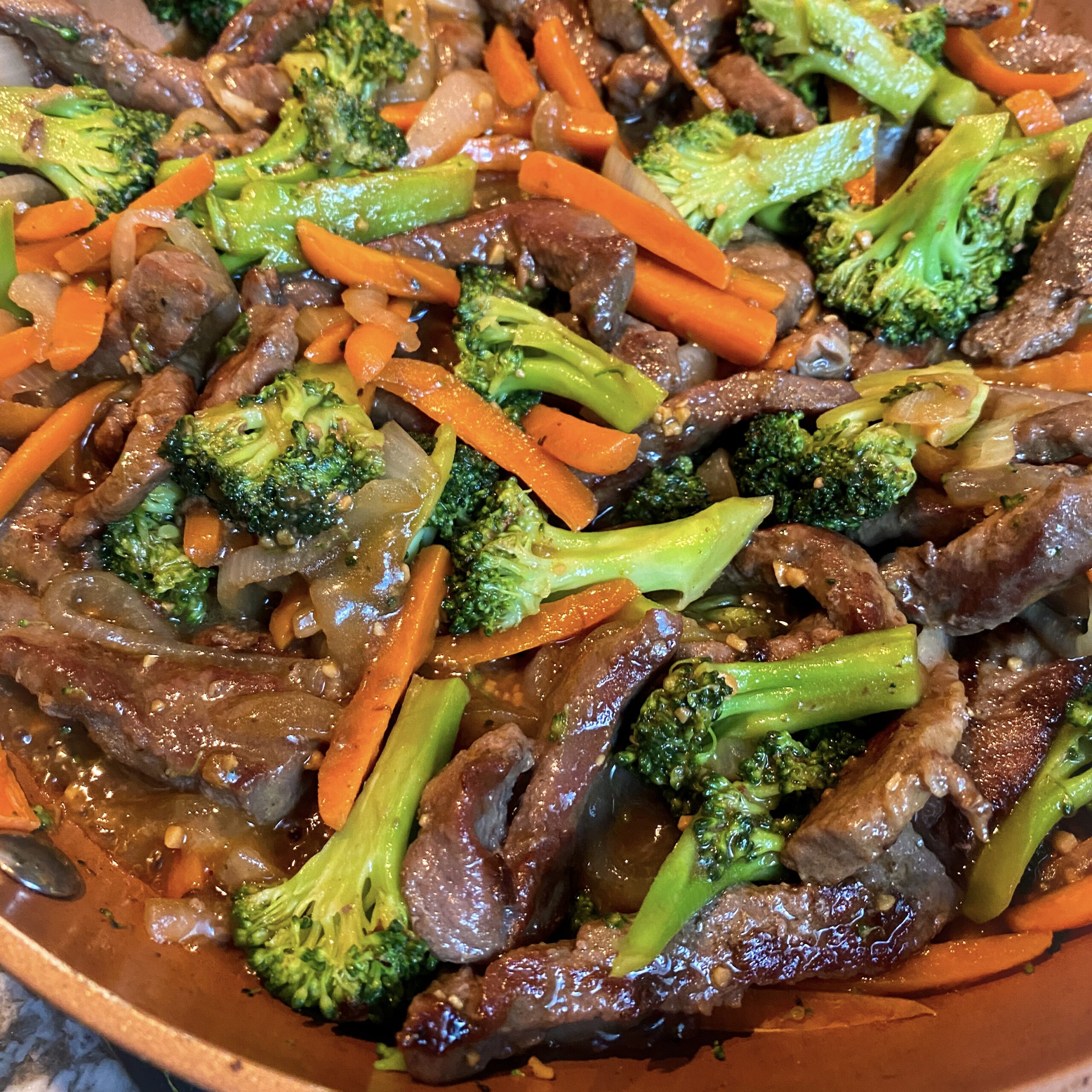 Stir fry sliced beef with shredded carrots and broccoli florets in a large skillet.